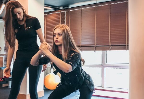 ems vs sport - femme portant un appareil ems autour du ventre lors d'un entrainement avec une coach qualifiée