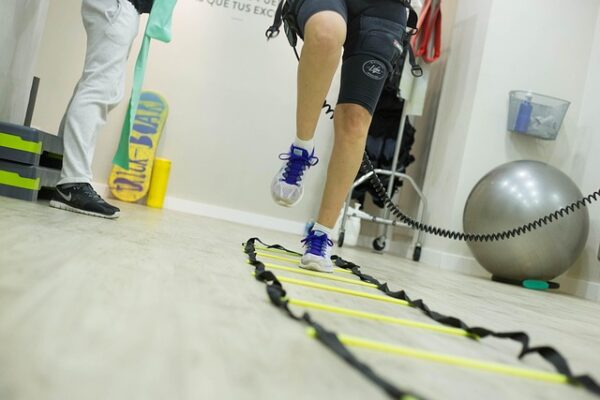 femme faisant de l'electrostimulation avec entrainement - reprise sportive